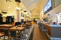ein Restaurant mit Holztischen und Stühlen und einer Bar in der Unterkunft Seastar Hotel and Service Apartment in Ban Chang