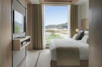 a hotel room with a bed and a large window at Amari Phuket in Patong Beach