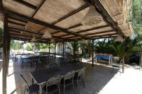 a patio with tables and chairs under a wooden roof at Duca di Castelmonte in Trapani