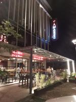 a restaurant with tables and a traffic light at night at Meisterstadt Pollux Habibie in Batam Center