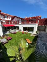 a large courtyard with a lawn in front of a building at Hôtel Kemaris in Biarritz