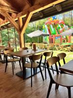 een restaurant met tafels en stoelen en een speeltuin bij Leśne Ustronie in Lubiszewo