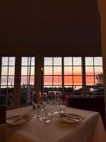 una mesa con copas de vino y vistas a la puesta de sol en Hotel Kysten, en Hasle