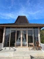 a house with glass windows and a wooden chair at The volcano in Kubupenlokan