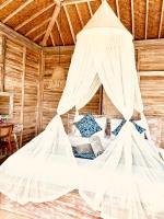 a bedroom with a bed with white mosquito net at The volcano in Kubupenlokan