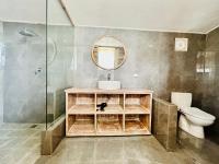 a bathroom with a sink and a toilet and a mirror at The volcano in Kubupenlokan