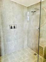 a bathroom with a shower with a glass door at The volcano in Kubupenlokan