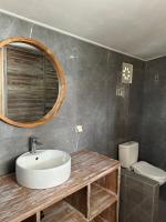 a bathroom with a sink and a mirror and a toilet at The volcano in Kubupenlokan