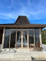 a house with glass windows and a wooden chair at The volcano in Kubupenlokan