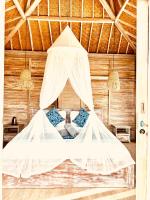 a bed in a room with a mosquito net at The volcano in Kubupenlokan