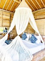 a bedroom with a bed with a mosquito net at The volcano in Kubupenlokan