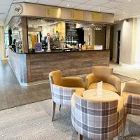 un restaurant avec un comptoir, une table et des chaises dans l'établissement The Chase Golf & Country Club, à Penkridge