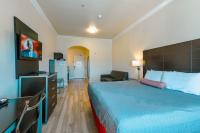 a hotel room with a large bed and a chair at Gateway Inn and Suites San Francisco SFO Airport in San Bruno