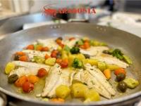 a pan of food with chicken and vegetables at Aragosta Hotel in Durrës