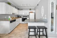 eine Küche mit weißen Schränken und 2 Barhockern in der Unterkunft Sunny escape in Miramar Beach in Destin