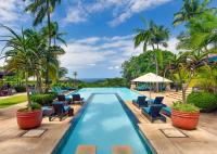 バリートにあるZimbali Lodge by Dream Resortsの椅子とヤシの木のあるプール