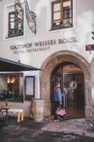 a woman standing outside of a hotel restaurant at Boutiquehotel Weisses Rössl in Innsbruck
