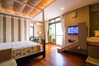 a bedroom with a bed and a flat screen tv at 宜人生活溜滑梯親子民宿 Easylife B&amp;B in Dongshan