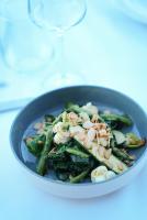 una ciotola blu di verdure con un bicchiere di vino di Dalyan Residence & Suites a Çeşme