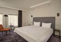 a bedroom with a large white bed and a chair at Park Plaza Eindhoven in Eindhoven