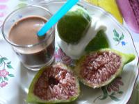 Un plato con dos rodajas de higos y una bebida. en chambre insolite dans un chalet, en Sampigny