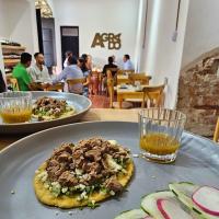 een bord eten met een pizza op tafel bij Agrado Guest House in Oaxaca City