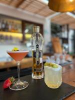 Dos cócteles y una botella de alcohol en una mesa. en Cantera 1910 Hotel Boutique, Destination Hotel, en San Miguel de Allende