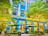 富国Laputa Hotel Phú Quốc的蓝色的建筑,前面设有桌子和遮阳伞