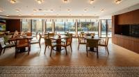 a dining room with tables and chairs and windows at UrCove By HYATT Chengdu Wenshu Monastery in Chengdu