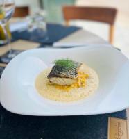 een witte plaat met een stuk voedsel op een tafel bij Auberge Kallisté - Eco Label in Porto Pollo