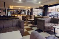 Un bar con sofás de cuero y suelo a cuadros. en Ovic Hotel, en Benin City