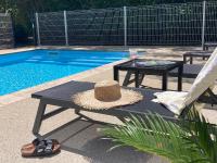 un sombrero sentado en una mesa junto a una piscina en Pavillon de l’Étang, en Châteauneuf-du-Rhône