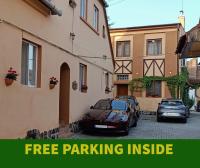 dos autos estacionados en un estacionamiento al lado de un edificio en Pensiunea Casa Sighisoreana, en Sighişoara