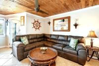 ein Wohnzimmer mit einem Ledersofa und einem Tisch in der Unterkunft Captains Quarters 3 Comm Pools Pet Friendly in Destin