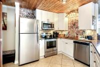 eine Küche mit weißen Schränken und einem Edelstahlkühlschrank in der Unterkunft Captains Quarters 3 Comm Pools Pet Friendly in Destin