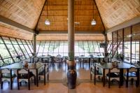 Casa Basilisa Hotel & Resort في Guinobatan: غرفة طعام مع طاولات وكراسي في مبنى