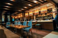 Un restaurante con una mesa y sillas y un bar. en Bel-La Monde Hotel Chhattarpur South Delhi, en Sat Bari