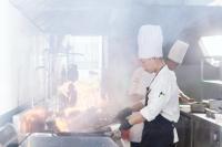 un ragazzino che cucina cibo su una griglia in cucina di Le Palmier Ho Tram Resort - Beachfront with Private Beach a Ho Tram