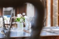 un tavolo con un vaso con fiori bianchi di Le Palmier Ho Tram Resort - Beachfront with Private Beach a Ho Tram