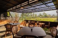 Un grupo de mesas y sillas en un patio. en Eagle Hotel Wonosobo, Azana Hotels Collection, en Kalianget