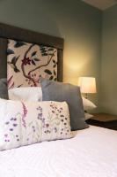 Una cama con sábanas blancas y almohadas con estampado floral. en the Cartwheel Inn, en Whitsbury