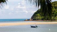 a boat sitting in the water on a beach at Maehaad Bay Resort - SHA Plus in Mae Haad