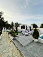 a patio with lounge chairs and a swimming pool at Skiathos Holiday Resort in Skiathos