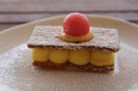 Un trozo de pan con una fruta encima en un plato. en Azar Luxury Suites, en Vlorë