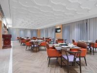 Un comedor con mesas y sillas en una habitación. en Vienna International Hotel Xi'an Fengdong Football Center Branch, en Doumen
