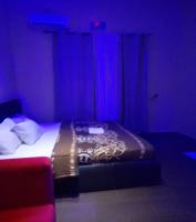 1 dormitorio con 1 cama con luces azules en Hotel Adonai Ltd, en Benin City