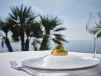 a white plate with a piece of food and a wine glass at La Villa Mauresque in Saint-Raphaël