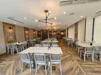 Un comedor con mesas blancas y sillas blancas. en Vittoria Hotel & Suites, en Niagara Falls