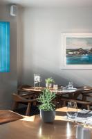 Un comedor con mesas con vasos y una planta en maceta. en Aeifos Boutique Hotel, en Imerovigli