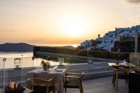 Un restaurante con vista al mar y a los edificios. en Aeifos Boutique Hotel, en Imerovigli